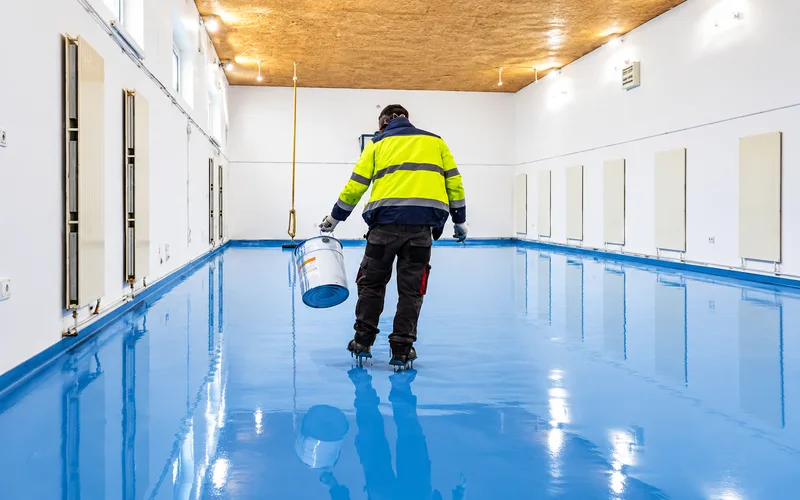 Bright View Painting technician on a newly coated blue epoxy floor