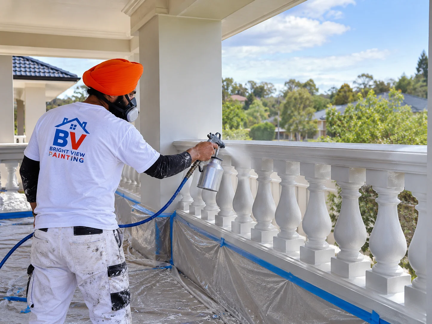 Painter spray painting a residential balustrade and railing
